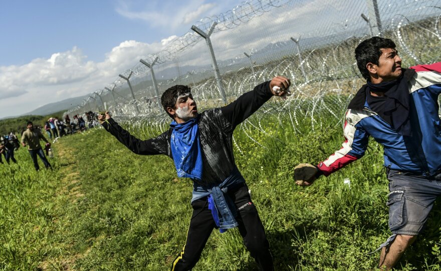 Refugees and migrants clash with Macedonian soldiers as they storm the border fence near Idomeni on Sunday.