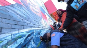 Terrence Floyd, the brother of George Floyd, kneels as he takes a moment in front of his brother's mural during a candlelight vigil in celebration of George Floyd's 47th birthday on Oct.14, 2020 in New York City.  (Michael M. Santiago/Getty Images)