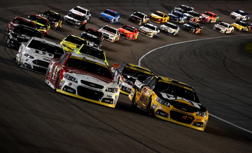 NASCAR drivers Kevin Harvick (in car on left) and Ryan Newman lead the pack during the Sprint Cup Series Ford EcoBoost 400 at Homestead-Miami Speedway on Nov. 16, in Homestead, Fla.