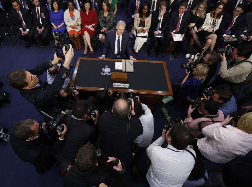 Supreme Court Justice nominee Neil Gorsuch surrounded by photographers.