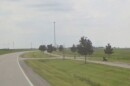 image of a hiking biking trail next to a rural road, with young trees along the side of the trail.