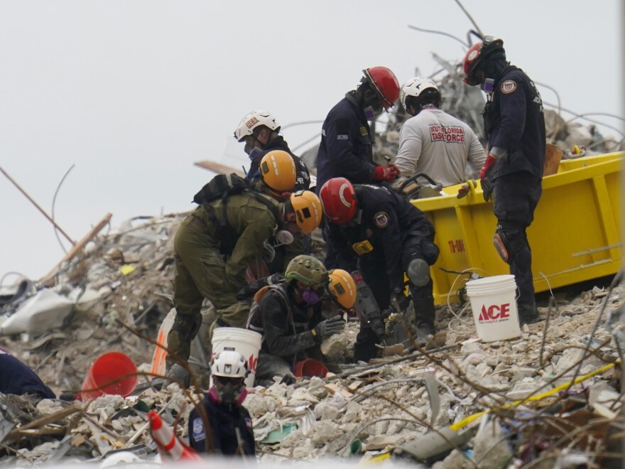 Crews work in the rubble of Champlain Towers South residential condo. The rescuers are searching urgently for the scores of souls buried beneath the fallen 12-story wing of the Champlain Towers condo building.