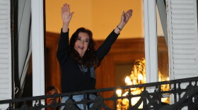 Former Argentine President Cristina Fernandez, who is serving a prison sentence under house arrest for corruption, waves from the balcony of her home during a rally marking the fourth anniversary of the assassination attempt against her in Buenos Aires, Argentina, Tuesday, Sept. 1, 2026.