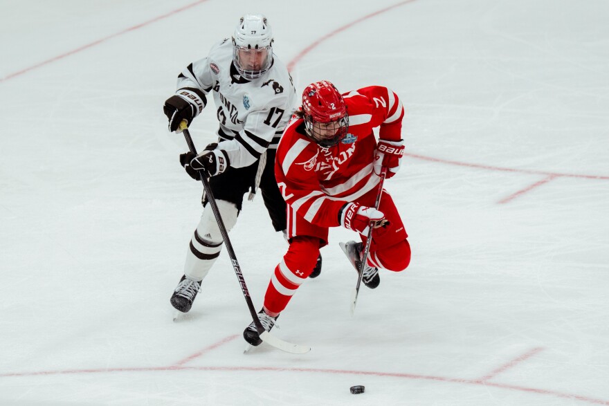Boston University defenseman Gavin McCarthy (2) attempts to get a hold of the puck while under pressure of Western Michigan forward Ty Henricks (17) during the NCAA men's ice hockey championship on Saturday, April 12, 2025, at Enterprise Center.