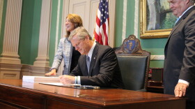 Massachusetts Governor Charlie Baker signs the fiscal 2019 budget in his office alongside Lt. Gov. Karyn Polito and Administration and Finance Secretary Mike Heffernan.