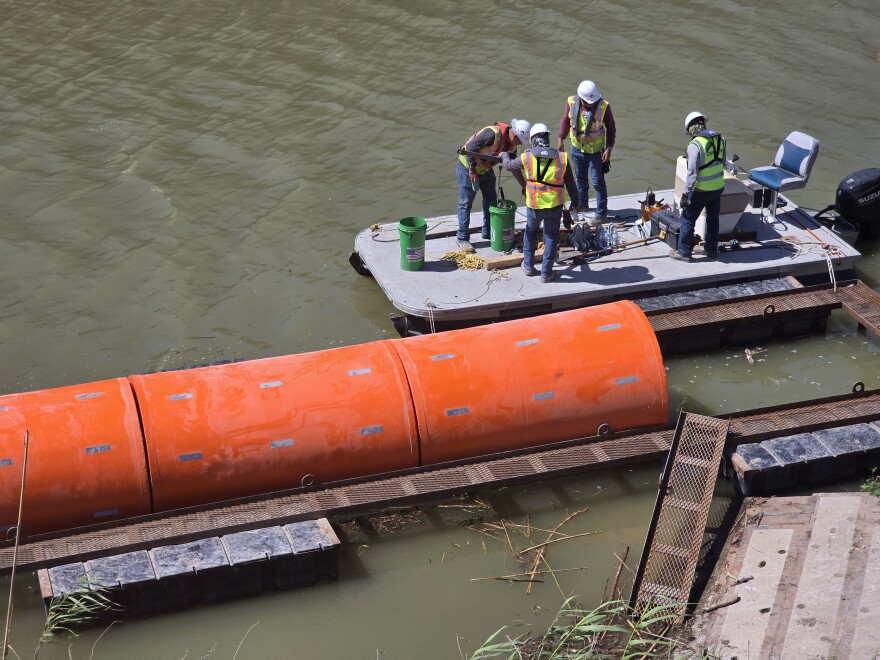 A work crew assmbles a string of buoys in the Rio Grande