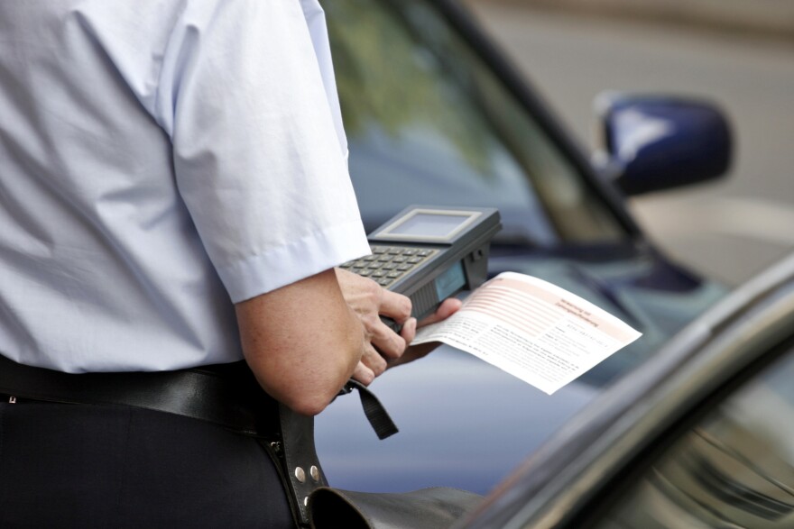 officer writing parking ticket