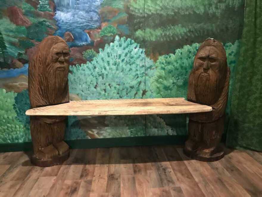 Hand-carved wooden bench depicting two Bigfoot. 