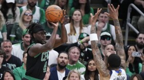 Boston Celtics guard Jrue Holiday takes a shot over Dallas Mavericks forward P.J. Washington (25) during the first half of Game 2 of the NBA Finals basketball series, Sunday, June 9, 2024, in Boston. (AP Photo/Steven Senne)
