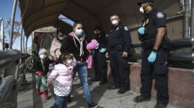  In this Friday, Feb. 26, 2021 file photo, a migrant family wearing face masks crosses the border into El Paso, Texas, in Ciudad Juarez, Mexico. (AP Photo/Christian Chavez)
