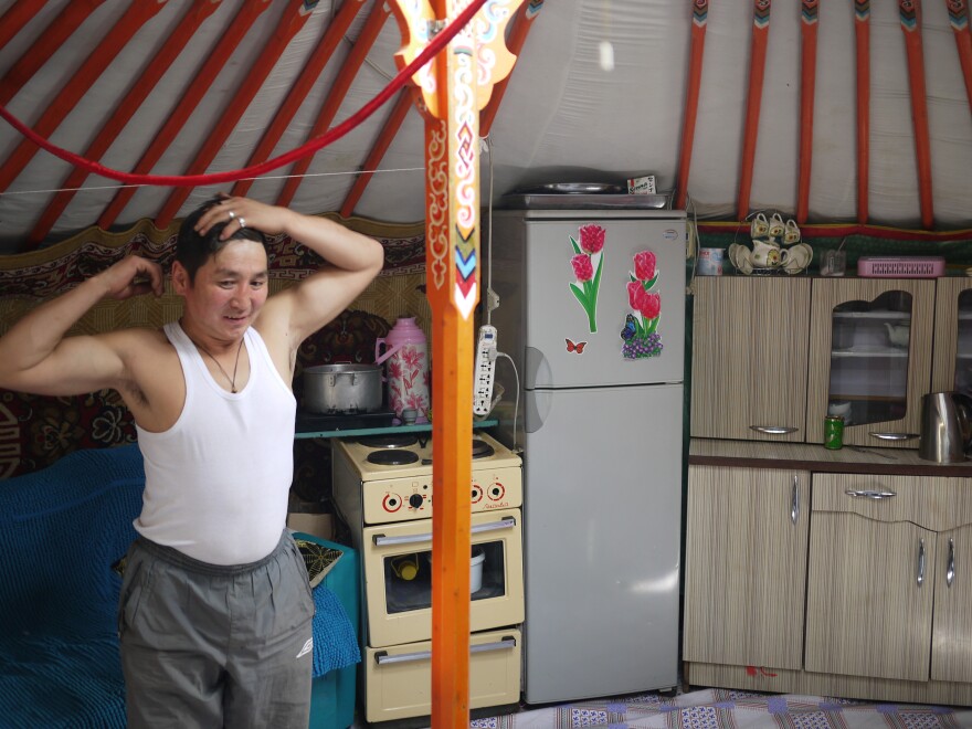 Gankhuyag, a former nomadic herder who now works in Ulaanbaatar as a porter, stands inside his ger on the outskirts of town.