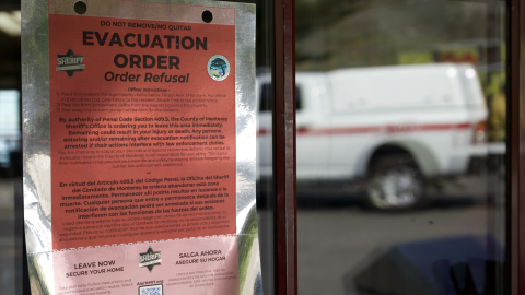 A red sign is stuck to a glass door. 
