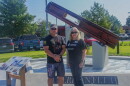Michael Terhune and Sharon Carraway stand in front of the steel beam that is part of the new 9/11 memorial at Tom Brown Park in Red Cross's front lawn