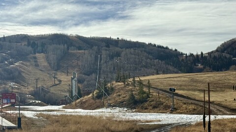 Machine-made snow slowly melts on Mountain Village ski school area Nov. 12, 2025. A thin white ribbon is seen at the top of Homerun.