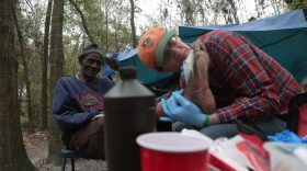 Roosevelt Anderson, a Tent City resident, receives care from Alex Templeton. Templeton is a traveling Catholic missionary who spent three months in Gainesville providing service to the less fortunate.