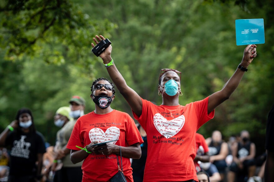 Vanessa Rouse, left, and Quinette Smith-Tanner of Milwaukee react to one of the speakers.