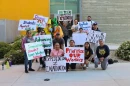 Farmworkers and UC Merced students pose with signs outside a side door Dr. Vikram and Priya Lakireddy Grand Ballroom at UC Merced on Friday, March 23, 2026.