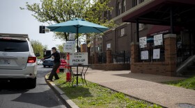A customer picks up a curbside order from MoKaBe's coffeehouse near Tower Grove Park. A small-business loan is helping cover the cafe's immediate financial needs, but its owner worries about the long term.