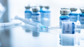 Some ampoules with covid-19 vaccine and syringe injection. Pandemic time.