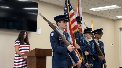 Christine Dobkowski (left) viewing the Belleview JROTC present the colors at the Freedom Walk event in the Belleview Community Center.