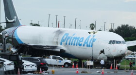 Workers inspect an Amazon cargo plane that overshot a runway four days ago at Miami International Airport, Thursday, Sept. 10, 2026, in Miami.