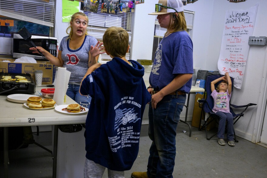 In the cow barn office space, Sara Shaw, left, of Shaw Farm in Oxford, Mass. prepares breakfast for her children William Buffun, 10, Michael Visbeek, 12, and Charlotte, 7. Shaw said her family’s “little hobby farm” has been showing cows for 45 years. "I met Shaw the night before when I was running through the fair and saw her pulling a wagon full of blankets and pillows and heading toward the cattle barn. "We sleep here" she said as I asked about the contents of the wagon. She didn't want me to disrupt her children's bedtime but the next morning she prepared breakfast in an office that was set up so the many contestants who also stayed with their cows during the night would could care for each other in the morning." - Mark Mirko