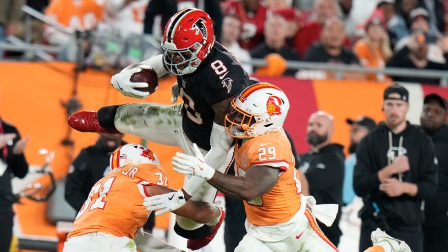 Falcons tight end Kyle Pitts Sr. (8) leaps over Tampa Bay's Christian Izien (29) during the first half of Thursday night's game in Tampa. Pitts caught three touchdown passes and finished with 11 receptions for 166 yards, becoming the first tight end with 150 yards receiving and three TDs since Hall of Famer Shannon Sharpe did it in 1996.
