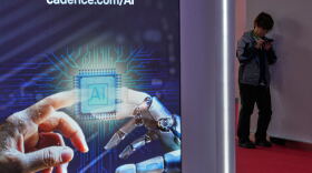 A man browses his phone near an artificial Intelligence (AI) booth at the China International Supply Chain Expo in Beijing on June 25, 2026.