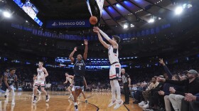 Fans watch as Villanova's Jhamir Brickus (2) runs to defend a three-point shot by UConn's Aidan Mahaney (20) during the first half of an NCAA college basketball game at the Big East basketball tournament Thursday, March 13, 2025, in New York. (AP Photo/Frank Franklin II)