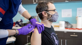 A person receives a COVID-19 vaccination at the Ball State University clinic location, operated by the Delaware County Health Department.