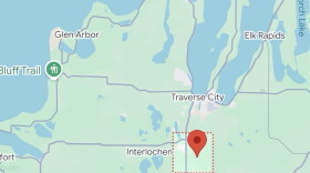 A map shows a pin dropped within a red box near Interlochen and Traverse City.