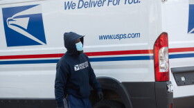 A mailman wearing a mask and gloves to protect himself and others from COVID-19 loads a postal truck with packages at a United States Postal Service (USPS) post office location in Washington, D.C., April 16, 2020. (Saul Loeb/AFP via Getty Images)