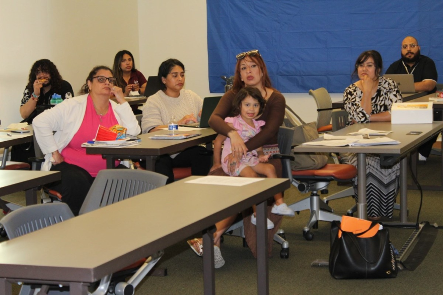 Daisy Ramos (center) holds her toddler during a tenant rights meeting on April 15, 2026. Policy advocates with Leadership Counsel For Justice and Accountability hosted the session to answer questions about the Merced City Council’s repeat housing code violators program ordinance.