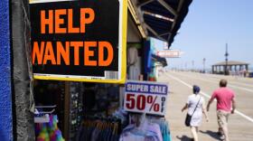 People walk past a help wanted sign in front of a souvenir shop along the boardwalk, in Ocean City, New Jersey. (Matt Slocum/AP)