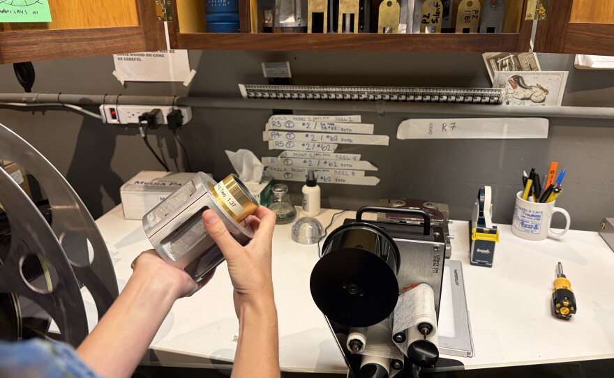 A projectionist holds a lens