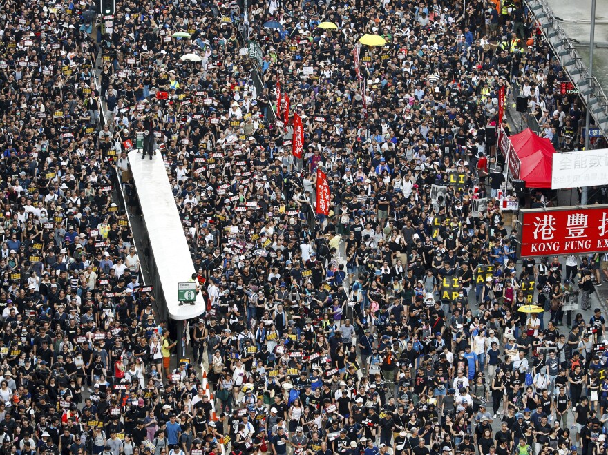Protesters take part in a march on a street in Hong Kong on Sunday. Thousands of Hong Kong protesters marched from a public park to call for an independent investigation into police tactics.