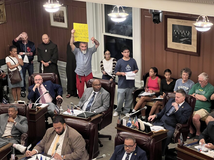 Observers listened from the rear of the New Bedford City Council chamber Tuesday as the council debated motions on the use of Flock surveillance cameras in the city.
