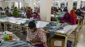 Garment workers wearing face masks work in a factory during a government-imposed lockdown as a preventative measure against the COVID-19 coronavirus on the outskirts of Dhaka on April 7, 2020. (Munir Uz Zaman/AFP/Getty Images)