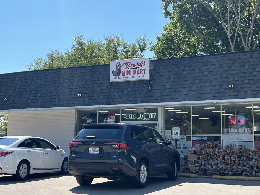 A store with car parked in front of it and a sign that reads "Beaver's Mini Mart" and a drawing of a beaver on it.