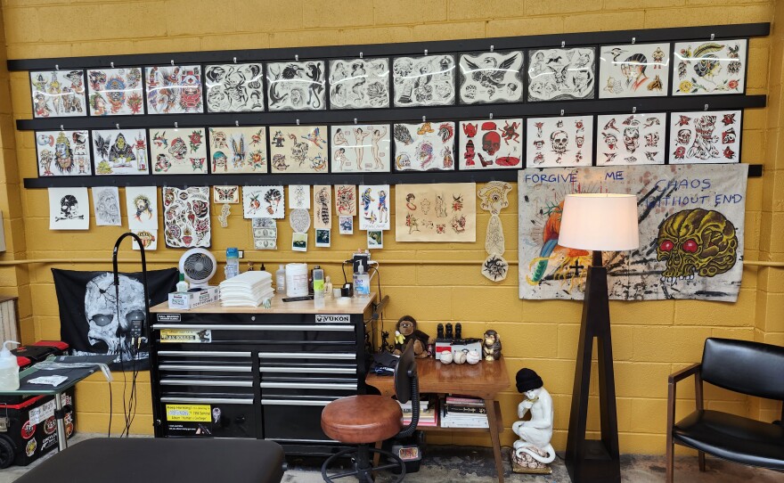 Images of tattoos hanging on a wall.