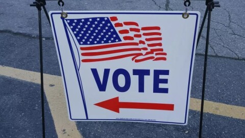 A sign points to a voting precinct