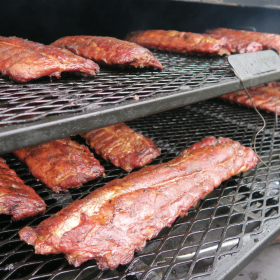 Ribs are prepared on the grill for a tailgate party.