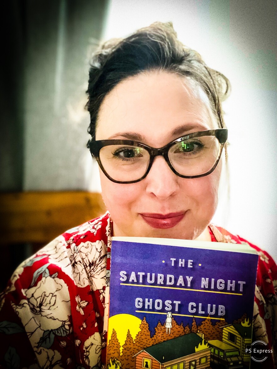 Domini Davis holds a copy of The Saturday Night Ghost Club. 