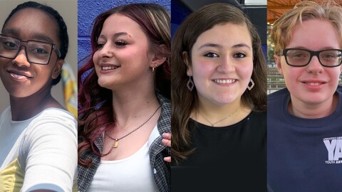 A photo of four teenagers smiling. 