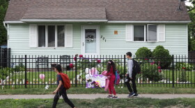 Neighborhood kids who were just dropped off by a school bus walk past 221 Emmerson where Zahira Smith, 16, of Rochester was shot and killed while attending a birthday party at the property Saturday night.