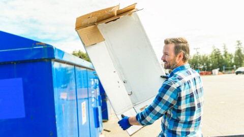 A worker recycling cardboard at a recycle center