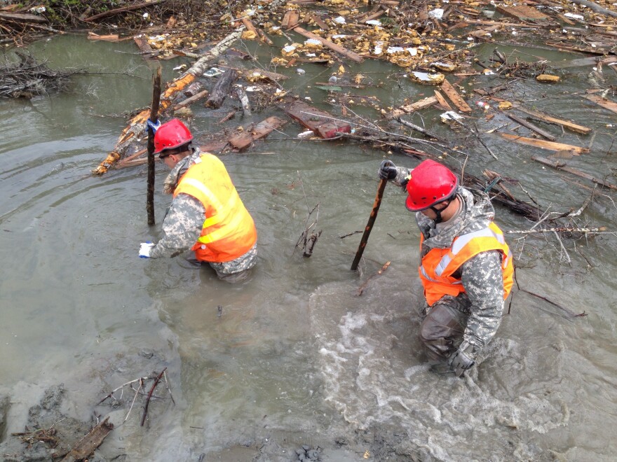 Two members of a search crew look for bodies near the scene of last month's mudslide in Washington state.