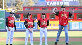 Morgan Maxey, Carl's grandson, throws out the ceremonial first pitch at King Carl Night, April 19. Spokane Indians players Kyle Karros, Chase Dollander and (left to right) look on.