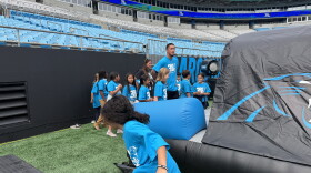 Carolina Panthers wide receiver Tetairoa McMillan spends time with students during the Panthers Field Day at Bank of America Stadium.