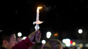 A candle is lifted into the air as residents of Newport News hold a candlelight vigil in honor of Richneck Elementary School first-grade teacher Abby Zwerner at the School Administration Building in Newport News, Va., Monday, Jan. 9, 2023. Zwerner was shot and wounded by a 6-year-old student while teaching class on Friday, Jan. 6. (AP Photo/John C. Clark)